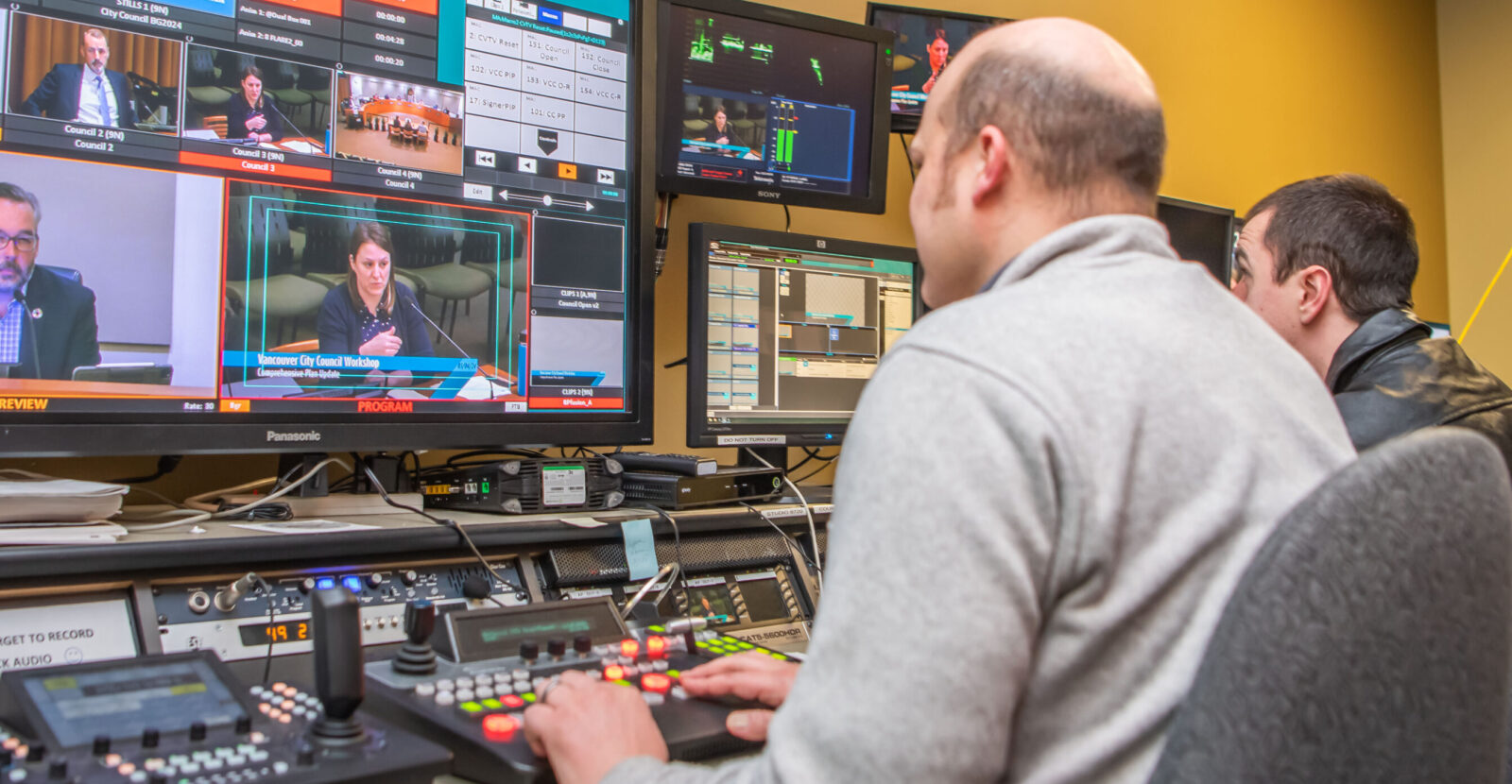 two men looking at monitors working with television equipment