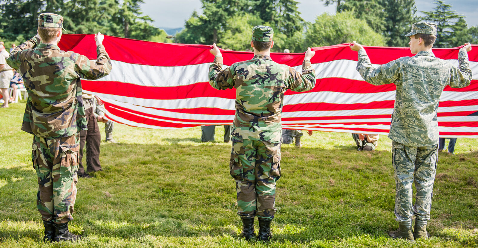 people in military uniform folding an American flag